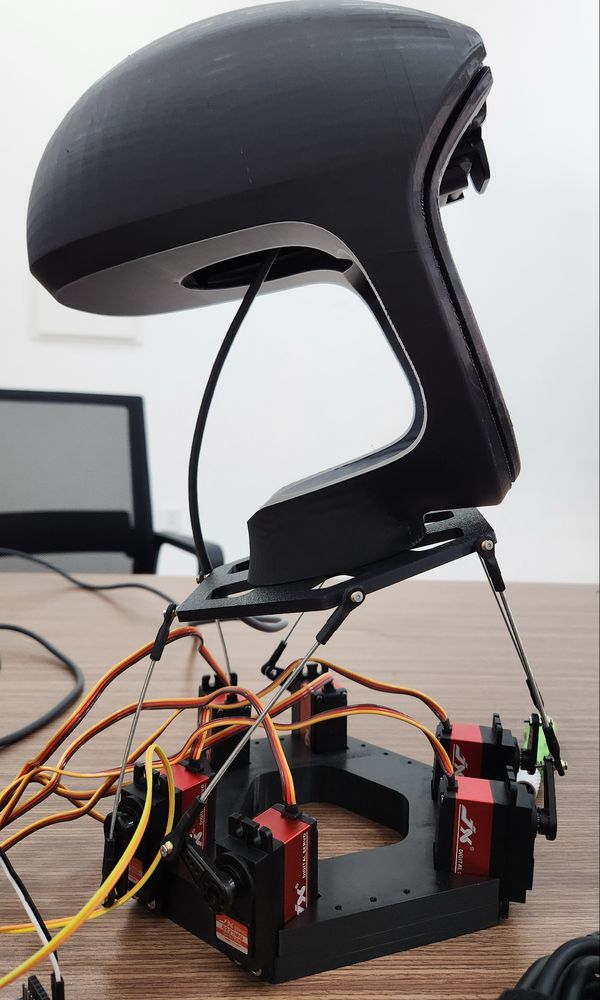 The same neck from the side, showing the curved head shell and the rods from the servo arms up to the top plate.